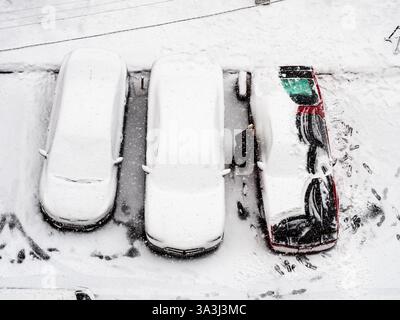 Vue ci-dessus du conducteur déneigant de la voiture le jour d'hiver dans la ville d'Erevan, Arménie Banque D'Images