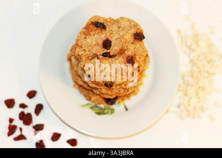 Délicieux gâteaux naturels de flocons d'avoine avec baies cuites à la maison pour les végétariens sur un fond blanc, fait à la main Banque D'Images