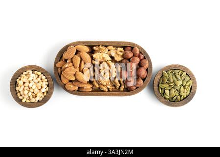 Noix mélangées dans des bols en bois isolés sur fond blanc. Vue de dessus Banque D'Images