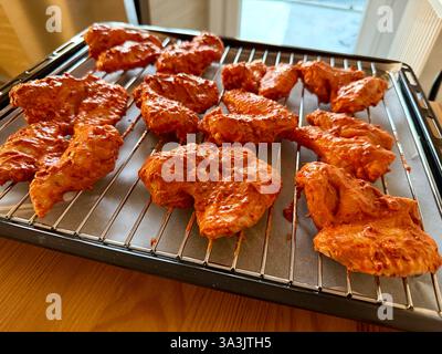 Ailes de poulet cru maison avec sauce sur grille Banque D'Images
