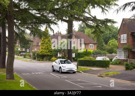 Londres, Royaume-Uni - 18 mai 2024. Tesla EV voiture conduisant dans une banlieue verdoyante de Londres. Pinner, Londres, Royaume-Uni Banque D'Images