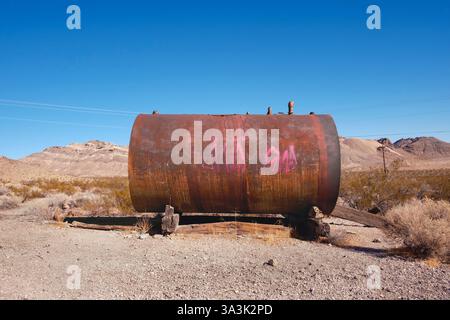 Réservoir de stockage en métal rouillé avec graffiti peint dans une ville fantôme abandonnée, Rhyolite, Nevada, USA Banque D'Images