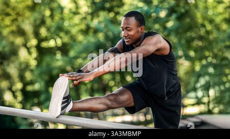 Un homme africain sportif s'entraînant à côté de la barre horizontale au parc Banque D'Images