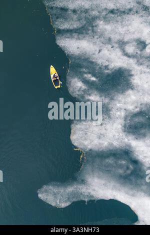 Prise de vue par drone d'un planchiste naviguant sur les eaux glacées d'un lac Banque D'Images