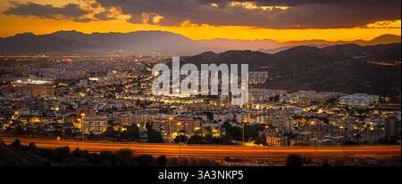 Vue panoramique de la ville de Malaga, regardant vers le bas sur les appartements urbains avec les montagnes et le coucher du soleil Banque D'Images