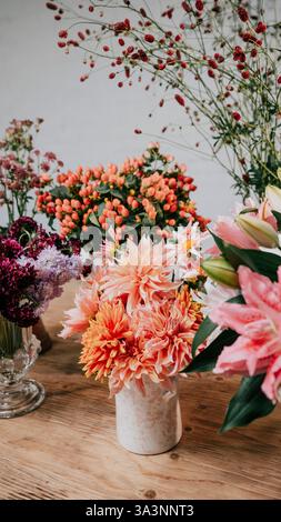 Une table avec un vase de fleurs et quelques autres vases de fleurs. Les fleurs sont de différentes couleurs et tailles, et les vases sont de différentes formes an Banque D'Images
