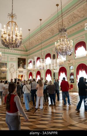 17 septembre 2024, Saint-Pétersbourg, Russie. Les touristes explorent les somptueux intérieurs du Grand Palais Peterhof en Russie, ornés de lustres et Banque D'Images