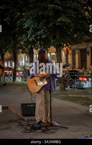 17 septembre 2024, Saint-Pétersbourg, Russie. Un musicien de rue captive un public dans un Pétersbourg, caressant une guitare acoustique tout en portant un cas Banque D'Images