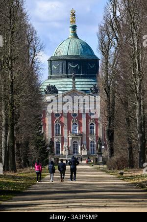 Potsdam, Allemagne. 17 mars 2025. Les promeneurs sont dehors et sur le bord du soleil dans le parc de Sanssouci sur l'avenue principale en direction du Nouveau Palais. Le parc de Sanssouci est l'un des sites les plus populaires de l'État de Brandebourg. Crédit : Jens Kalaene/dpa/Alamy Live News Banque D'Images