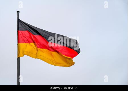 Drapeau de l'Allemagne agitant contre le ciel sur le mât de drapeau Banque D'Images