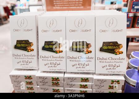 23 janvier 2025, Abu Dhabi, Émirats arabes Unis : barres de chocolat Dubaï avec garniture de kunafa et de pistache empilées sur une étagère de magasin, prêtes à être achetées Banque D'Images