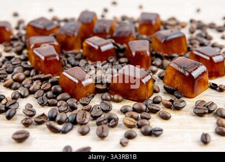 Vue de côté de glaçons de café éparpillés sur la table, décorés avec des grains de café. Prise de vue en studio. Concept de glaçons de café pour faire du café glacé. Banque D'Images