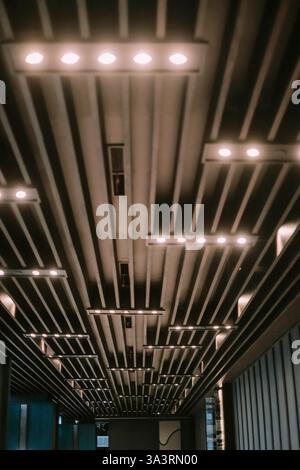 Un design de plafond architectural moderne avec un arrangement rythmé d'éléments linéaires avec éclairage intégré. Le motif crée un vis frappant Banque D'Images