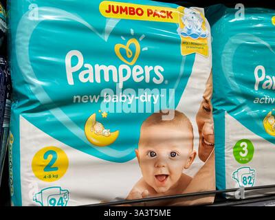 Bobruisk, Biélorussie - 2 mars 2025 : les fournitures pour bébés aux couleurs vives attirent l'attention dans une allée de magasin, présentant des couches pour bébés. Banque D'Images