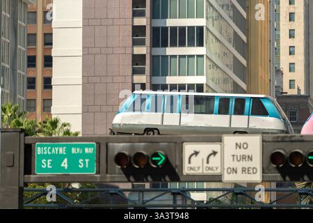 Transport urbain dans le centre-ville de Miami Brickell en Floride USA. Metrorail City train wagon sur la voie ferrée haute sur la circulation routière entre Banque D'Images