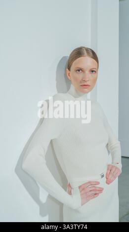 Kiev, Ukraine - 14 février 2025. Un mannequin pose en toute confiance dans une superbe tenue blanche et ajustée, mettant en valeur l'élégance et la grâce Banque D'Images