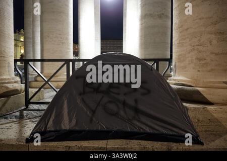Cité du Vatican, Italie. 17 mars 2025. Cité du Vatican, Italie 17.03.2025 : un sans-abri dort dans sa tente sous la colonnade de celle de Pierre, avec les mots Dieu bénisse que vous avez écrits sur la tente. Crédit : Agence photo indépendante/Alamy Live News Banque D'Images