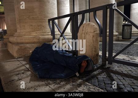 Cité du Vatican, Italie. 17 mars 2025. Cité du Vatican, Italie 17.03.2025 : un sans-abri dort dans un sac de couchage sous la colonnade de celui de Pierre, avec les mots Dieu bénisse que vous avez écrits sur sa tente. Crédit : Agence photo indépendante/Alamy Live News Banque D'Images