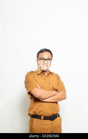 Professeur asiatique indonésien avec des lunettes debout en regardant avec confiance la caméra sur fond blanc Banque D'Images
