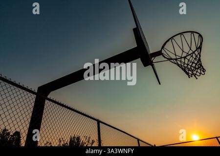 WA17856-00..... WASHINGTON - lever de soleil dans le ciel rempli de fumée sur un terrain de basket abandon dans la communauté de Whitestone. Banque D'Images