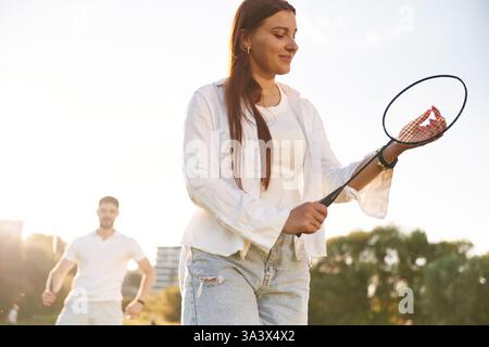 Homme avec femme jouent au badminton sur le terrain. Banque D'Images