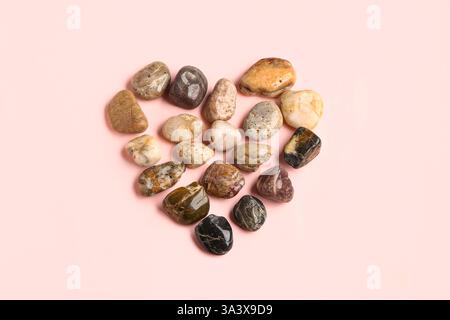 Coeur fait de pierres de galets sur fond rose Banque D'Images