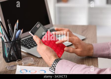 Mains masculines faisant des calculs au bureau. Gros plan Banque D'Images