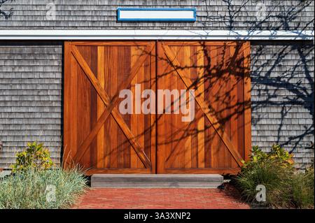 Moderne extérieur style grange porte coulissante en bois sur bardeaux maison couverte, Cape Code Banque D'Images