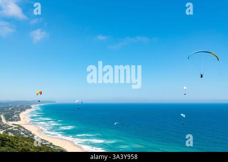 Personnes parapente au-dessus de la côte de Wilderness dans le Cap occidental, Afrique du Sud Banque D'Images