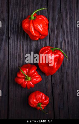Vue de dessus sur les poivrons rouges habanero mûrs (capsicum chinense) sur la table rustique en bois. Les poivrons mexicains très chauds se rapprochent Banque D'Images