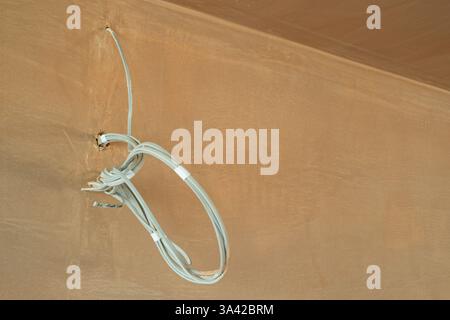 Une salle nouvellement plâtrée avec commutation électrique, premiers inserts de câblage. Travaux de construction finis avec une surface plane lisse de plâtre mince. Banque D'Images