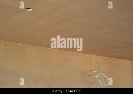 Une salle nouvellement plâtrée avec commutation électrique, premiers inserts de câblage. Travaux de construction finis avec une surface plane lisse de plâtre mince. Banque D'Images