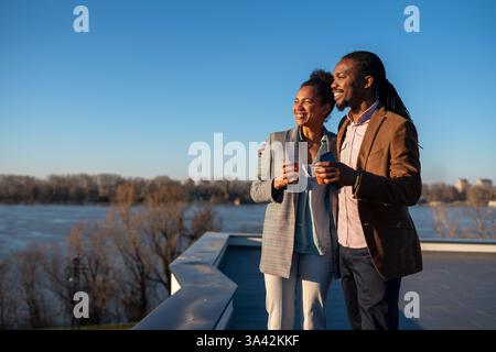 Un homme et une femme d'affaires joyeux habillé dans chic décontracté ayant une conversation sur le café en pause Banque D'Images