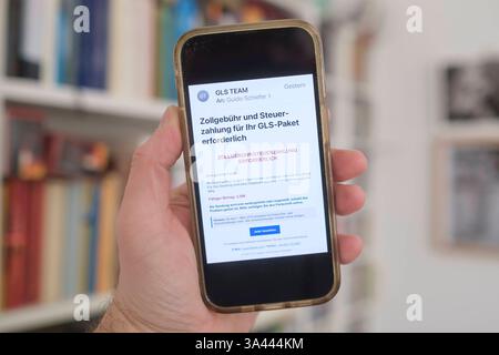 Hand mit Mobiltelefon auf dem eine betrügerische Email zu sehen ist, die eine angebliche Zollgebühr bzw Steuernachzahlung für ein Paket einfordert. *** Main avec un téléphone portable montrant un courriel frauduleux exigeant un prétendu paiement de frais de douane ou de taxes pour un colis. Rhénanie-du-Nord-Westphalie Deutschland, Allemagne GMS18791 Banque D'Images