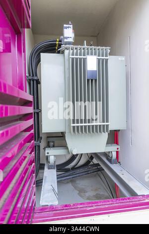 Grand transformateur dans un boîtier à cadre rose avec câbles, construction d'armoires électriques, construction de systèmes photovoltaïques, principaux clients, Enzkreis, Allemagne, Europ Banque D'Images