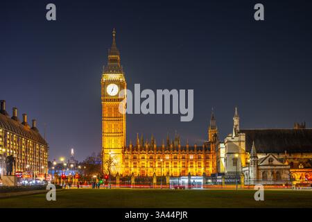 Big Ben se tient grand contre le ciel nocturne, brillant de lumière dorée. La tour de l'horloge historique, qui fait partie des chambres du Parlement, attire les visiteurs au cœur de Londres. Banque D'Images