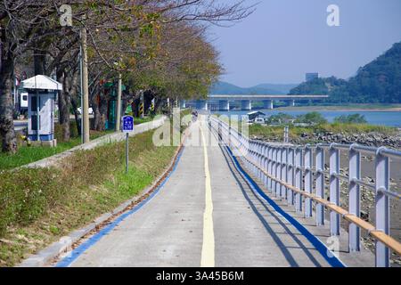 Ville de Gwangyang, Corée du Sud - 3 octobre 2021 : une section de la piste cyclable Seomjingang est parallèle à la rivière, bordée de cerisiers et d'une sécurité Banque D'Images