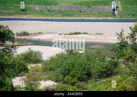 Ville de Gwangyang, Corée du Sud - 3 octobre 2021 : une vue sereine sur la rivière Seomjingang avec un banc de sable, une végétation verte et un pataugeoire d'aigrette solitaire Banque D'Images