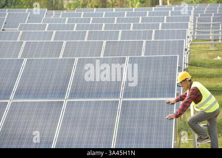 Ingénieur travaillant sur des panneaux solaires dans une centrale solaire, Thaïlande Banque D'Images