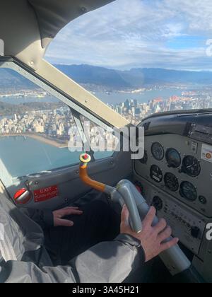Gros plan d'un pilote dans un avion privé survolant la côte de Vancouver, Colombie-Britannique, Canada Banque D'Images