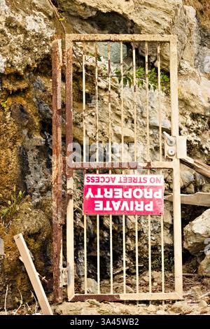 porte de portail cassée à la base d'une falaise Banque D'Images