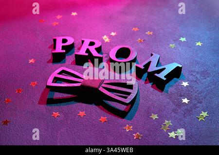 PROM mot avec confettis et noeud papillon sur fond grunge noir Banque D'Images