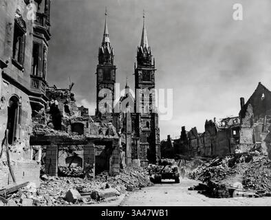 Les derniers jours de la seconde Guerre mondiale (1945) et le 45e régiment d'infanterie américain et un char Sherman M4 avancent à travers les décombres de Nuremburg en Allemagne Banque D'Images