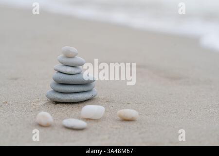 Pierres zen empilées sur une plage de sable symbolisant l'équilibre, le calme et l'harmonie dans la nature. Banque D'Images
