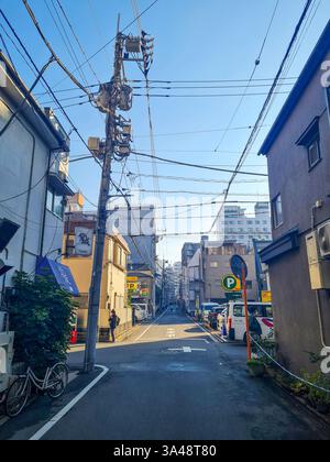 Petite rue arrière à Asakusa, Tokyo avec des maisons, des immeubles d'appartements et un ciel bleu clair. Banque D'Images