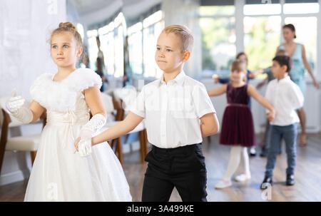 Tween filles ad garçons dansant la danse partenaire lente pendant l'événement festif Banque D'Images