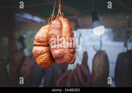 Sremski Kulen, une saucisse serbe traditionnelle, est vu suspendu dans un étal de marché en Serbie. Cette image met en valeur les détails complexes et traditionnels Banque D'Images