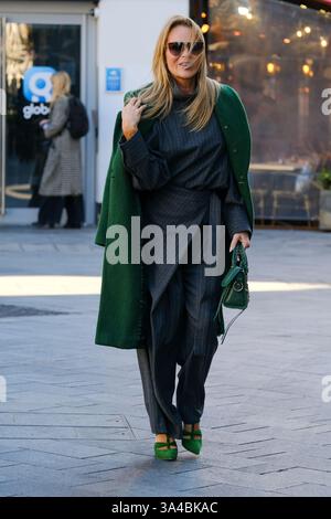 Amanda Holden quitte Global Studios après avoir présenté son émission de petit-déjeuner Heart Radio dans un pantalon gris, un manteau vert et des sandales à brides. Banque D'Images