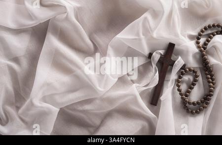Concept du vendredi Saint et de la semaine Sainte - Une croix religieuse sur fond de tissu blanc. Banque D'Images