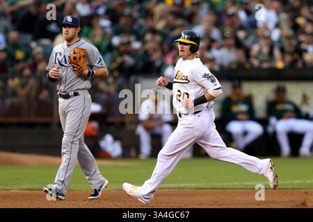 5 août 2014 - Oakland, CA, USA - Josh Donaldson (20) de l'Oakland Athletics avance de la deuxième à la troisième place sur un terrain sauvage alors que le troisième joueur de base des Rays de Tampa Bay Evan Longoria regarde dans la première manche au Coliseum O.co à Oakland, Calif, le mardi 5 août 2014. (Crédit image : © Ray Chavez/MCT/ZUMA Wire) Banque D'Images